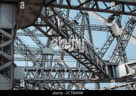 Guardando verso l'alto le travi metalliche e le forme triangolari del ponte Howrah a Kolkata, India Foto Stock