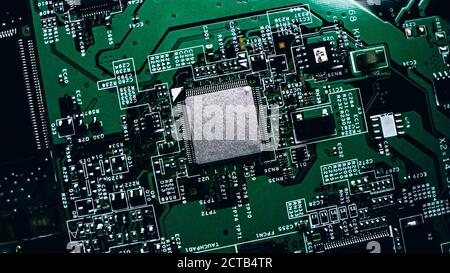 Macro primo piano di Microchip, processore CPU su scheda a circuito stampato nera, scheda madre per computer con componenti all'interno del dispositivo elettronico, parte Foto Stock