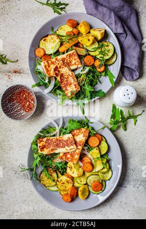 Alloumi alla griglia con verdure alla griglia su un piatto grigio. Concetto di cibo vegetariano. Foto Stock