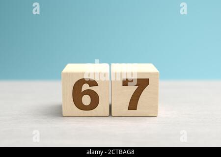 Blocchi di giocattoli di legno che formano il numero 67. Foto Stock