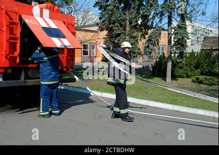 Tubo flessibile di messa in campo antincendio, un altro controllo di una pompa dell'acqua durante l'addestramento Foto Stock