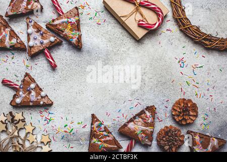 Brownie dell'albero di Natale con canna da zucchero candita e glassa, sfondo grigio. Concetto di cibo di Natale. Foto Stock