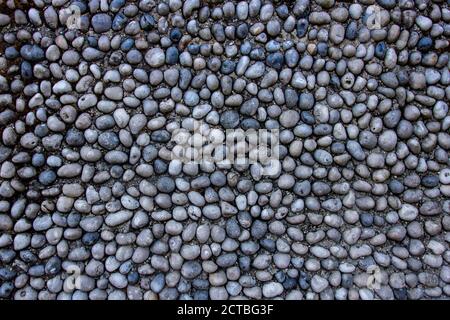 Ciottoli su fondo di cemento. Colore grigio e disposizione piatta Foto Stock