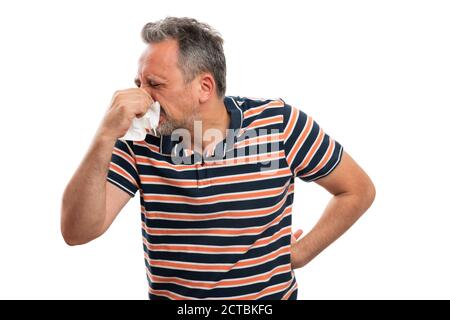 Il modello dell'uomo adulto starnutisce coprendo il naso e la bocca usando il tessuto come covid19 freddo sintomo malato concetto di indossare abiti estivi casual tshirt isolato su wi Foto Stock