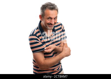 Uomo adulto sorridente che presenta manica di maglietta estiva a righe pollice in su come gesto d'accordo come elegante abito casual moda isolato su stu bianco Foto Stock