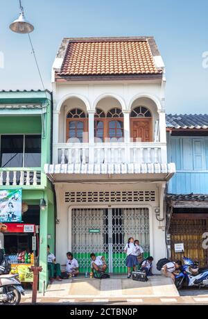 Phuket, Thailandia - 26 febbraio 2018: Vecchia casa bianca e scolari in attesa di un bus scolastico Foto Stock