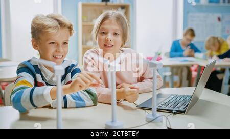 Studentessa e studentessa lavorano con il prototipo della turbina eolica, imparando a conoscere l'ambiente e l'energia rinnovabile . Scuola elementare di scienza con Foto Stock