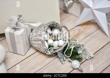 Disposizione di Natale con un cestino, palle di Natale su uno sfondo di legno chiaro Foto Stock