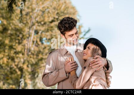 uomo in trench mano di contatto di donna in cappello esterno Foto Stock