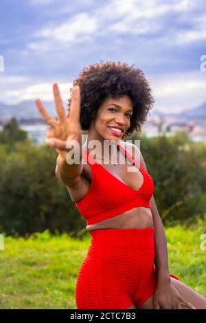 Immagine verticale di una bella donna ispanica nera che indossa abbigliamento sportivo Foto Stock