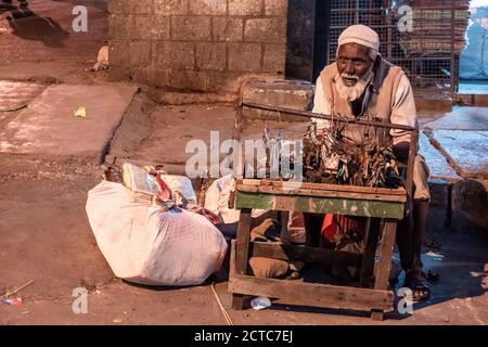 Bengaluru, Karnataka, India - Gennaio 2019: Un vecchio indiano che vende serrature e chiavi per le strade del mercato KR nella città di Bangalore. Foto Stock