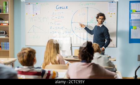 Foto di insegnante che spiega la lezione in aula piena di diversi Bright Children, nel gruppo scolastico elementare di Smart multietnica Bambini Learning Science Foto Stock