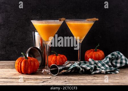 Cocktail di zucca su tavolo di legno e sfondo nero Foto Stock