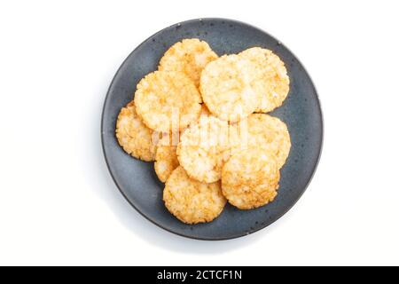 Biscotti tradizionali giapponesi con patatine di riso e salsa di miele su un piatto di ceramica blu isolato su sfondo bianco. Vista dall'alto, primo piano, piatto. Foto Stock