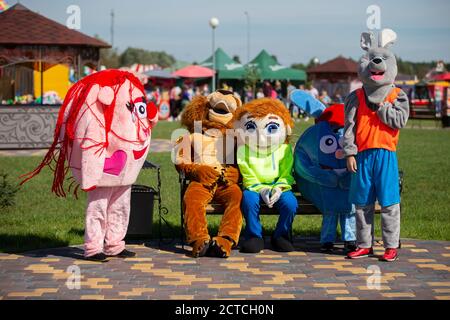 08 29 2020 Bielorussia, Lyaskovichi. Celebrazione in città. Gli artisti in costumi di pelliccia siedono sulla panchina stanchi. Foto Stock