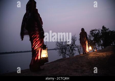 Bengala Occidentale, India. 2 Feb 2016. I residenti locali dell'isola di Gosaba camminano lungo la riva del fiume in serata illuminando la loro strada con le lanterne cherosine. L'isola di Gosaba è completamente tagliata dalla rete elettrica principale e l'energia solare sta cominciando ad essere installata per portare una certa luce a queste zone remote. Credit: Supratim Bhattacharjee/ZUMA Wire/Alamy Live News Foto Stock