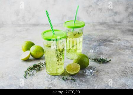 Due bicchieri con limonata con timo e ghiaccio su sfondo chiaro. Rinfrescanti cocktail estivi fatti in casa alcolici o non alcolici o infuso di Detox Foto Stock