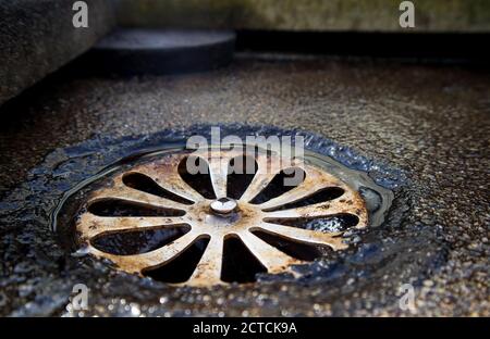 Pulizia dello scarico sul patio, sul ponte o sul balcone sul tetto. Prevenzione delle inondazioni o dei danni causati dall'acqua. Primo piano. Tampone di supporto in gomma per sollevare le piastrelle dal pavimento Foto Stock