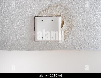 Danni all'acqua sul soffitto del popcorn. Macchia d'acqua gialla saturata e appiattita le aree. Foto Stock