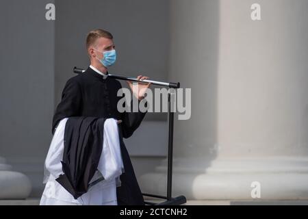 Giovane sacerdote con maschera protettiva che va alla chiesa Per celebrare la messa durante la seconda ondata di Covid o Coronavirus focolaio Foto Stock