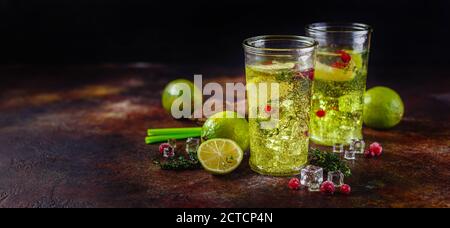 Due bicchieri con lime limonata con timo, mirtillo e ghiaccio su fondo chiaro. Cocktail alcolici o non alcolici fatti in casa o flavo infuso da Detox Foto Stock