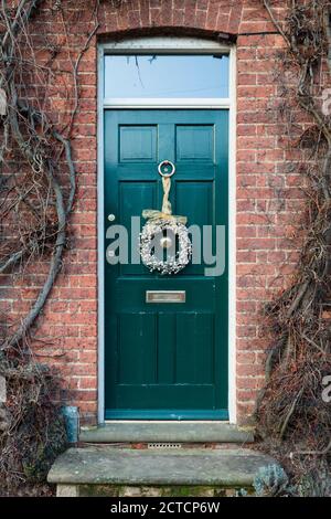 WINSLOW, Regno Unito - 29 dicembre 2019. Porta anteriore fuori di una casa nel Regno Unito al tempo di Natale, porta dipinta di verde, teal, con la corona di Natale Foto Stock