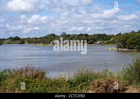 Hayling Island Golf Club, Hayling Island, Hampshire, Inghilterra, UK - Vista del Lago Sinah con la batteria Heavy Anti-Aircraft Sinah sullo sfondo Foto Stock