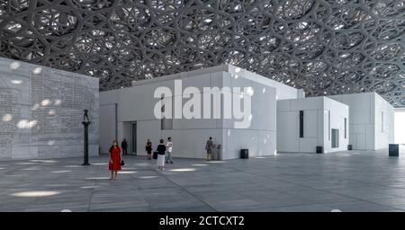 Un'immagine interna del Louvre Abu Dhabithche include i visitatori, il tetto ad alta tecnologia con luce filtrante e le pareti bianche della facciata dei suoi vari spazi espositivi. Aperto a novembre 2017. Foto Stock