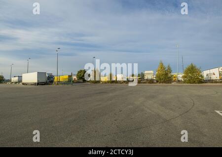 Splendida vista panoramica del terminal logistico DHL. Camion parcheggiati su un territorio enorme su cielo blu con sfondo nuvole bianche. Foto Stock