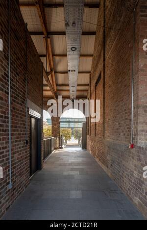 Coal Drops Yard di Heatherwick Studio è un quartiere commerciale di King's Cross, Regno Unito. Completato nel 2018 è un progetto di riutilizzo adattivo di ex magazzini del carbone. Dettaglio di una galleria di accesso. Foto Stock