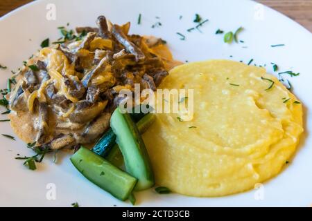 Piatto di stroganoff di manzo con purè di patate e cetrioli a San Pietroburgo, Russia. Foto Stock