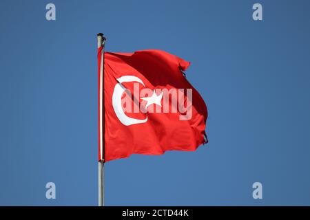 Bandiera della Turchia che svanisce su sfondo blu chiaro del cielo Foto Stock