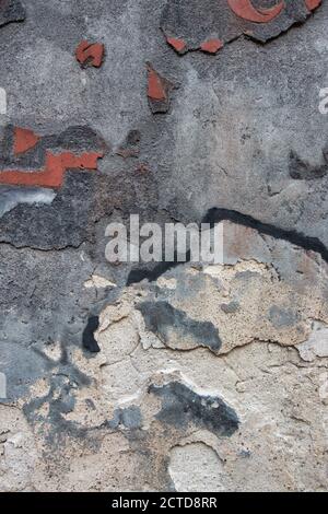Vecchio decrepito sporco fondo parete intonaco con struttura fessurata. Vecchio muro di Malta grigio nero con stucco sbucciato ruvido e superficie sbucciata Foto Stock