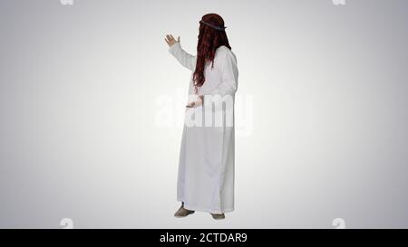 Uomo arabo che indossa il kefiyeh facendo un gesto di benvenuto su gradiente ba Foto Stock