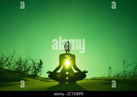 Silhouette di una persona che fa yoga con la radice chakra simbolo Foto Stock