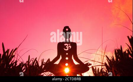 Silhouette di una persona che fa yoga con la radice chakra simbolo Foto Stock