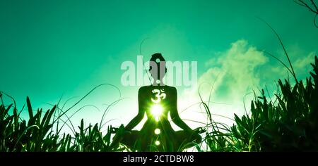 Silhouette di una persona che fa yoga con la radice chakra simbolo Foto Stock