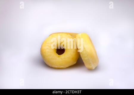 Tre deliziose ciambelle classiche su sfondo bianco Foto Stock