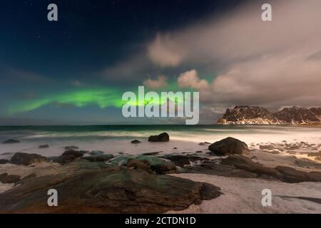 Bellissima aurora boreale sull'isola di Lofoten in Norvegia. Aurora boreale sulla spiaggia. Maestoso cielo notturno verde. Nightscape Full os stars. Foto Stock