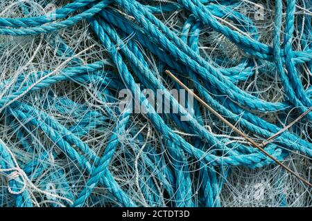 Closeup di corde blu e reti da pesca l'una sull'altra sotto la luce del sole Foto Stock