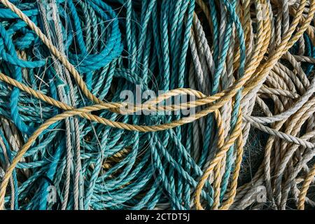 Closeup di corde blu e reti da pesca l'una sull'altra sotto la luce del sole Foto Stock