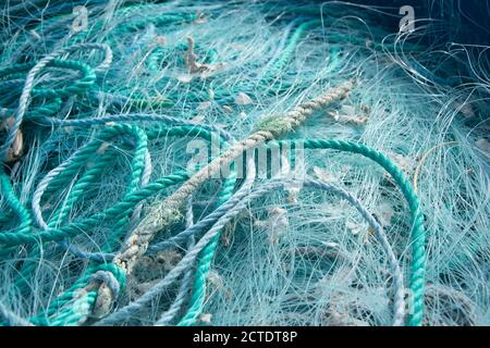 Closeup di corde blu e reti da pesca l'una sull'altra sotto la luce del sole Foto Stock