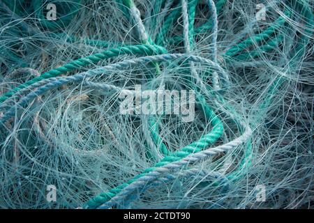 Closeup di corde blu e reti da pesca l'una sull'altra sotto la luce del sole Foto Stock