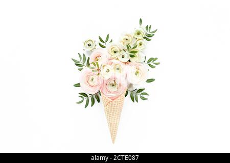 Cono di cialda con bouquet di fiori di ranuncolo su sfondo bianco. Piatto, vista dall'alto sfondo floreale. Foto Stock