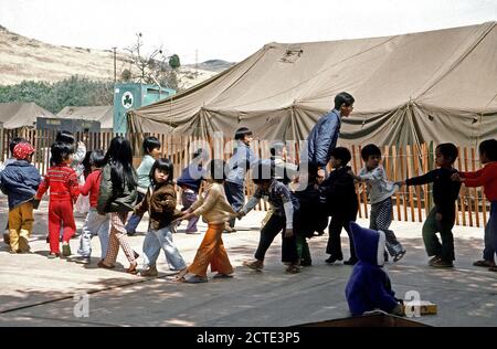 1975 - i bambini giocano a una temporanea struttura alloggiativa per rifugiati vietnamiti. Foto Stock