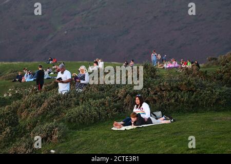 Rhossili, Gower, Galles, Regno Unito. 21 settembre 2020 le persone impaccheggiano le scogliere di Rhossili Bay sulla costa di Swansea Gower, per ammirare un tramonto spettacolare alle spalle Foto Stock