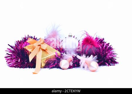 Primo piano di un bel Natale bauble accanto a una confezione regalo in oro su uno sfondo chiaro. Regali di Natale e decorazione concetto. Foto Stock