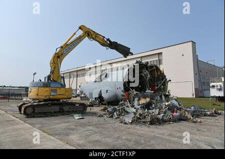 Un appaltatore utilizza un escavatore per rimuovere un allenatore statico C-130 vicino alla linea di volo alla base dell'aeronautica Hanscom, Mass., settembre 15. L'aeromobile, che è stato qui dall'ottobre 1982, è stato utilizzato per l'addestramento da squadroni del porto aereo e dal reparto dei vigili del fuoco durante gli esercizi di base. (STATI UNITI Air Force foto di Todd Maki) Foto Stock