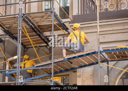 costruttori in uniforme lavoro in un cantiere. Foto Stock