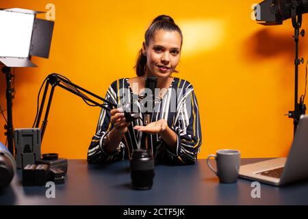 Donna che prova l'apparecchiatura vlog in studio domestico professionale. Nuovi media star influencer sui social media Talking video attrezzature fotografiche per internet web show online. Foto Stock